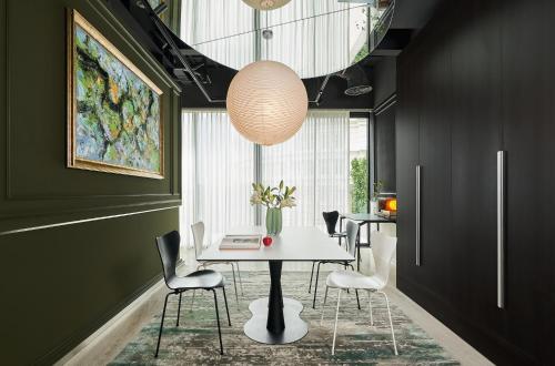 a dining room with a white table and chairs at Signature by M Village Hai Bà Trưng in Ho Chi Minh City