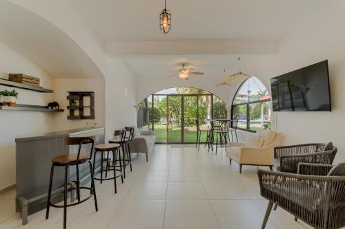 a living room with chairs and tables and a bar at CHIC Lagoon front Villa by Casa Paraíso in Cancún
