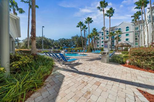 a resort with a swimming pool and palm trees at HSO - Family Apartments Close to Disney World & Universal in Orlando