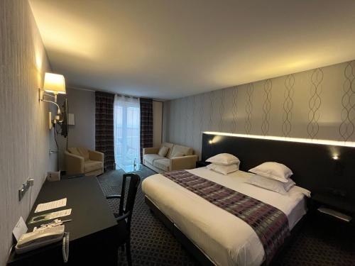a hotel room with a bed and a desk at Best Western Plus La Fayette Hotel et SPA in Épinal