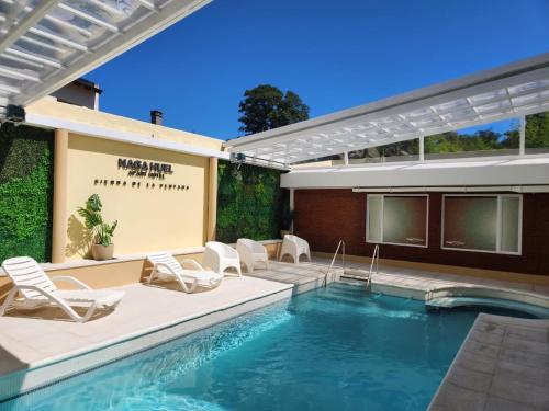a swimming pool with lounge chairs and a swimming pool at Apart Hotel Naga Huel in Sierra de la Ventana