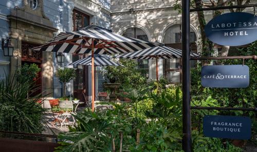 a patio with two umbrellas in front of a building at Labotessa Luxury Boutique Hotel in Cape Town