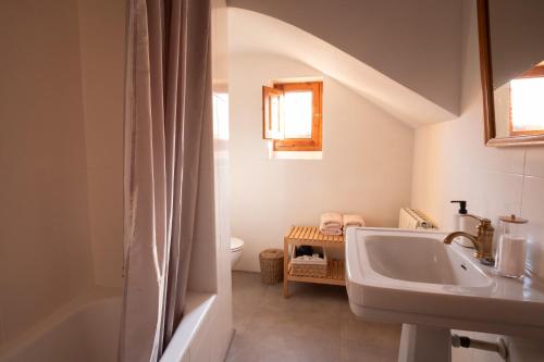 a bathroom with a sink and a tub and a toilet at La Casa Amarilla in Rubielos de Mora