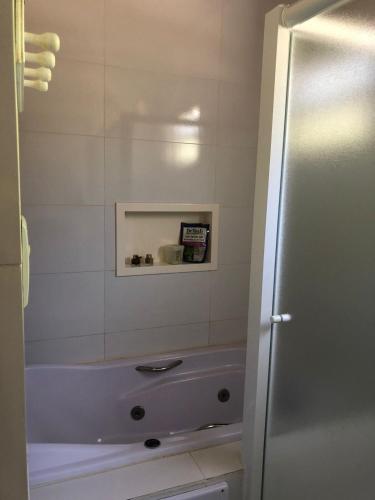a bathroom with a bath tub and a sink at Casa Maldonado Morada da Praia 4 suítes in Bertioga