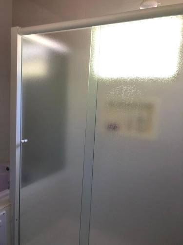 a stainless steel refrigerator in a kitchen with a window at Casa Maldonado Morada da Praia 4 suítes in Bertioga