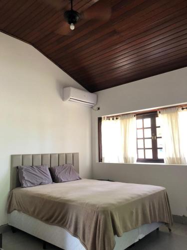 a bedroom with a bed and a window at Casa Maldonado Morada da Praia 4 suítes in Bertioga