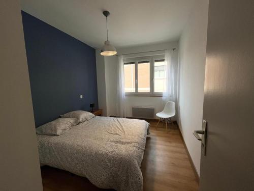 une chambre avec un lit, une fenêtre et une chaise dans l'établissement La Côte Pavée I T4, à Toulouse
