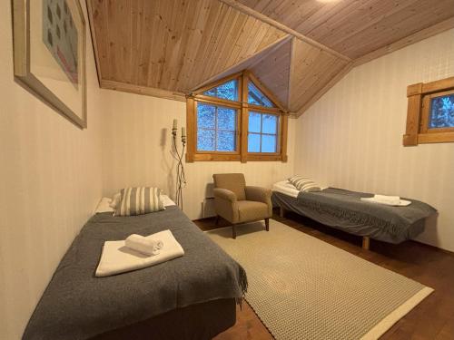 a room with two beds and a chair in it at Villa Vielma in Levi