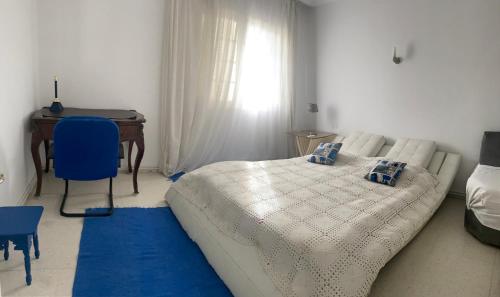 a bedroom with a bed and a desk and a table at Maison Avec terrasse Garage in La Marsa