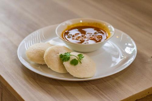 a plate with biscuits and a bowl of soup at Mayflower Airport Launge cochin international airport in Nedumbassery