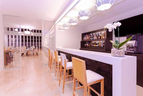 a bar in a restaurant with chairs and a counter at NH Puebla FINSA in Puebla