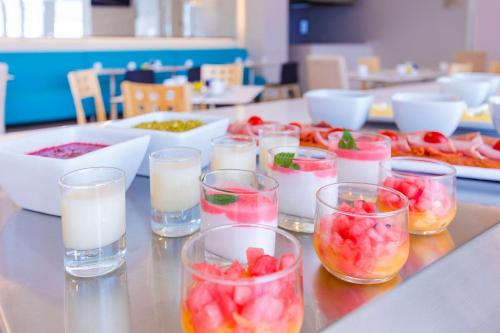 a table topped with glasses of milk and fruit at NH Puebla FINSA in Puebla