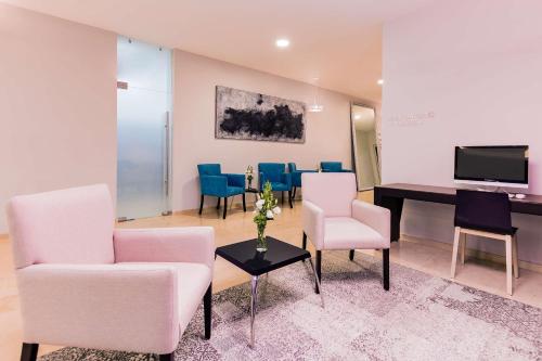 a living room with a piano and chairs and a table at NH Puebla FINSA in Puebla