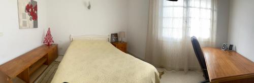 a bedroom with a bed and a desk and a window at Maison Avec terrasse Garage in La Marsa