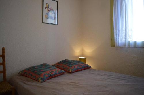 une chambre avec un lit avec deux oreillers dessus dans l'établissement Appartement 2 pièces 4 couchages ST CYPRIEN PLAGE SC510-85F, à Saint Cyprien Plage