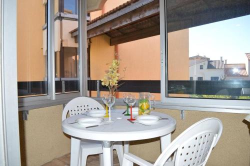 une table blanche avec deux chaises et une table avec des verres dans l'établissement Appartement 2 pièces 4 couchages ST CYPRIEN PLAGE SC510-85F, à Saint Cyprien Plage