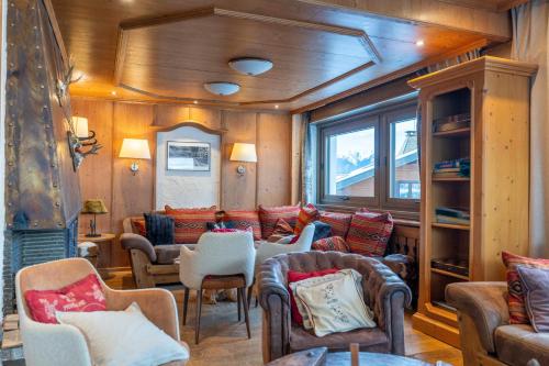 a living room with couches and chairs in a house at Hôtel Macchi Restaurant & Spa in Châtel