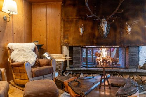 a living room with a fireplace with antlers on the wall at Hôtel Macchi Restaurant & Spa in Châtel