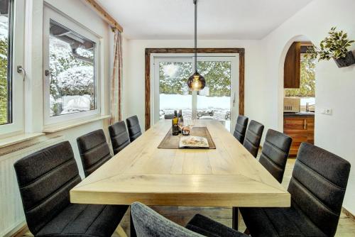 a dining room with a wooden table and chairs at Chalet Sabrina mit Außenpool im Sommer in Kaprun