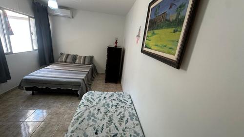 a room with a couch and a picture on the wall at Apê da Praia in Cabo Frio