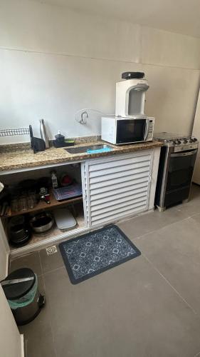 a kitchen with a counter with a microwave on it at Apê da Praia in Cabo Frio