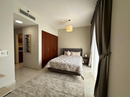 a bedroom with a bed and a large rug at Lagoon Studio Apartment - Nexus Holiday Homes in Ras al Khaimah