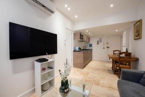 un salon avec une grande télévision à écran plat sur un mur dans l'établissement 1-Br Apartment with AC in the Heart of Cannes, à Cannes