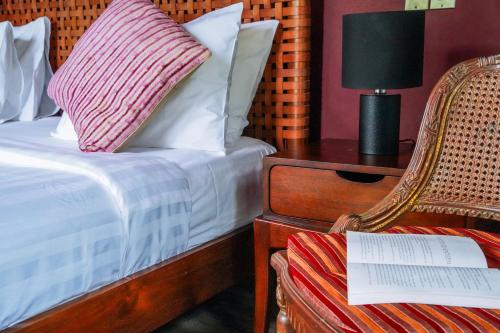 a bedroom with a bed and a chair and a table at Villa Gita Segara Candidasa in Candidasa