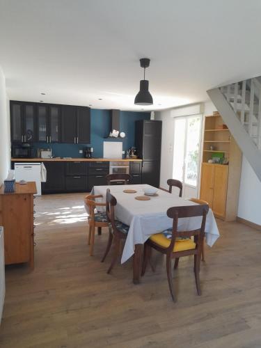 une cuisine avec une table et des chaises dans une pièce dans l'établissement Country house near Nevers, à Cours-les-Barres