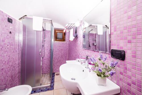różowa łazienka z 2 umywalkami i prysznicem w obiekcie B&B La Casa Di Plinio w mieście Pompeje