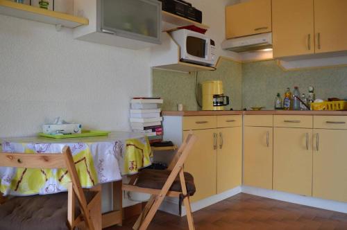 une cuisine avec une table et des chaises et un micro-ondes dans l'établissement Appartement Studio cabine 4 couchages SAINT CYPRIEN SC070-065, à Saint Cyprien Plage