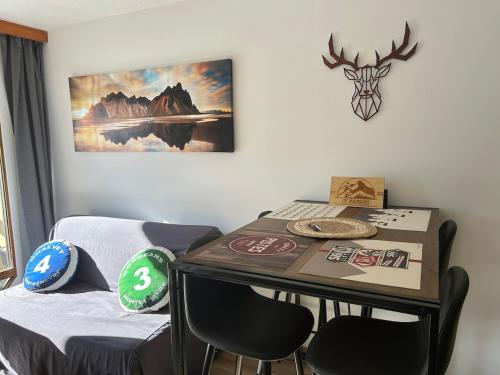 Cette chambre dispose d'une table avec des chaises et d'une photo murale. dans l'établissement Les Marmottes, à Montgenèvre