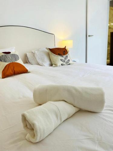 - un lit blanc avec des couvertures et des oreillers blancs dans l'établissement Gare du Nord - Large renovated apartment, à Paris