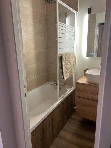 une salle de bain avec une baignoire et un lavabo dans l'établissement Les Marmottes, à Montgenèvre