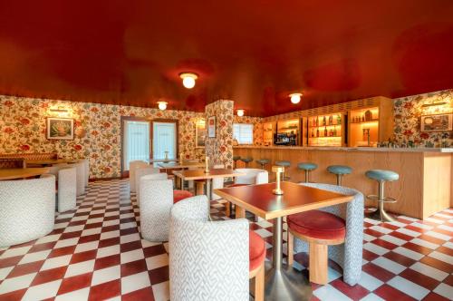 a restaurant with tables and chairs and a checkered floor at Royal Sun Palm Springs in Palm Springs