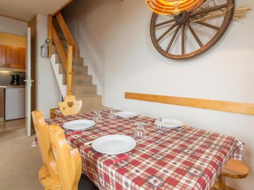 une table de salle à manger avec une nappe à carreaux dans l'établissement Duplex spacieux proche pistes avec balcon - FR-1-181-2493, à La Plagne Tarentaise