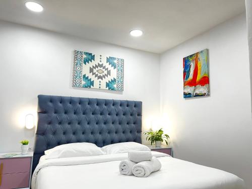 a bedroom with a king sized bed with a blue headboard at Tirana Square Hotel in Tirana