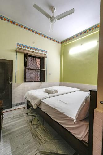 a bedroom with a large bed with a ceiling fan at Hotel Bawarri Haveli in Jodhpur