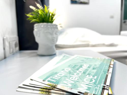 a book sitting on top of a table with a vase at Tirana Square Hotel in Tirana