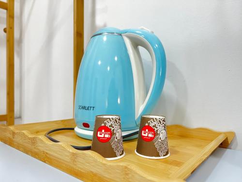 a blue kettle and two cups on a wooden shelf at Tirana Square Hotel in Tirana