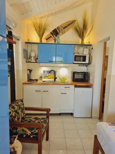 a kitchen with white cabinets and a microwave at Gites Kaladja in Port-Louis