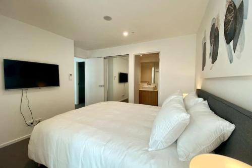 a bedroom with a large white bed with pillows at Modern 2BR Apt Adelaide CBD with Pool-Gym-BBQ in Adelaide