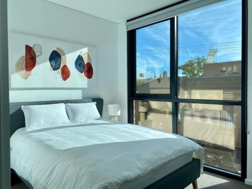 a bedroom with a bed and a large window at Modern 2BR Apt Adelaide CBD with Pool-Gym-BBQ in Adelaide