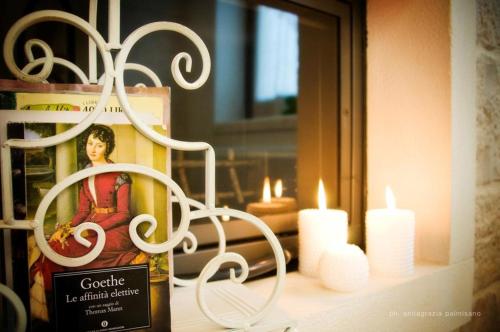 a shelf with candles and a bottle of wine at Trulli Magravì - Apparthotel in Alberobello