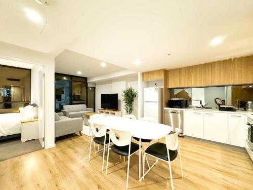 a kitchen and living room with a white table and chairs at Urban Sanctuary in West Franklin with Pool & Gym in Adelaide