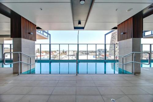 a swimming pool in a building with large windows at Contemporary 3BR Paradise on Franklin Street in Adelaide