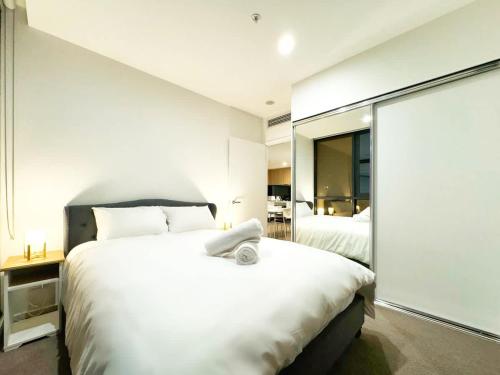 a bedroom with two beds and a large mirror at Urban Sanctuary in West Franklin with Pool & Gym in Adelaide