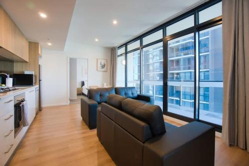 a living room with a couch and a large window at Contemporary 3BR Paradise on Franklin Street in Adelaide