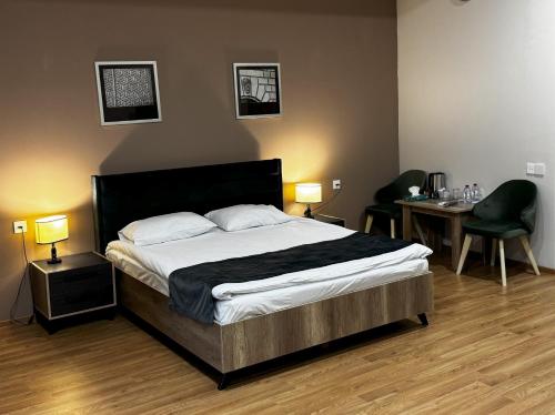 a bedroom with a bed and a table and chairs at Arena Hotel Neftchala in Neftçala