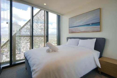 a bedroom with a white bed and large windows at City Escape at Rundle Mall - Gym & BBQ in Adelaide